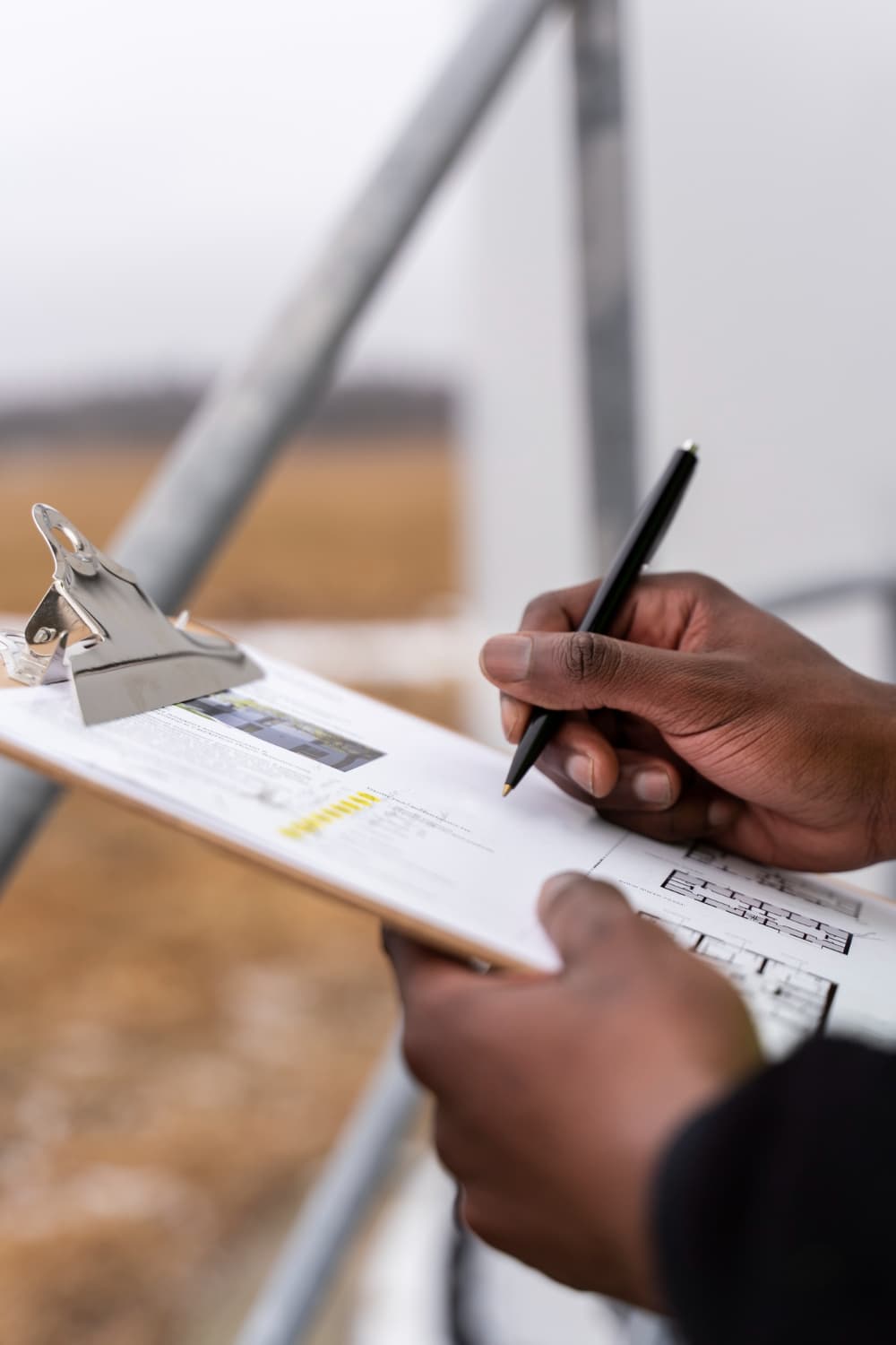 Hands writing on clipboard