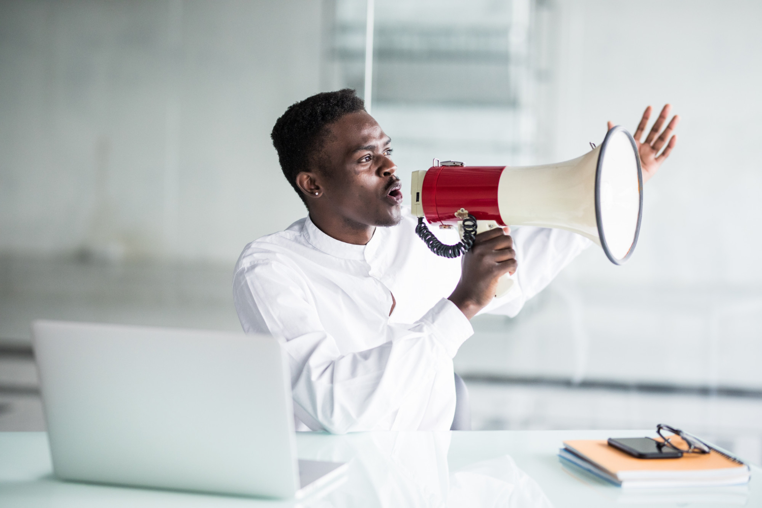 Man with a megaphone at a desk