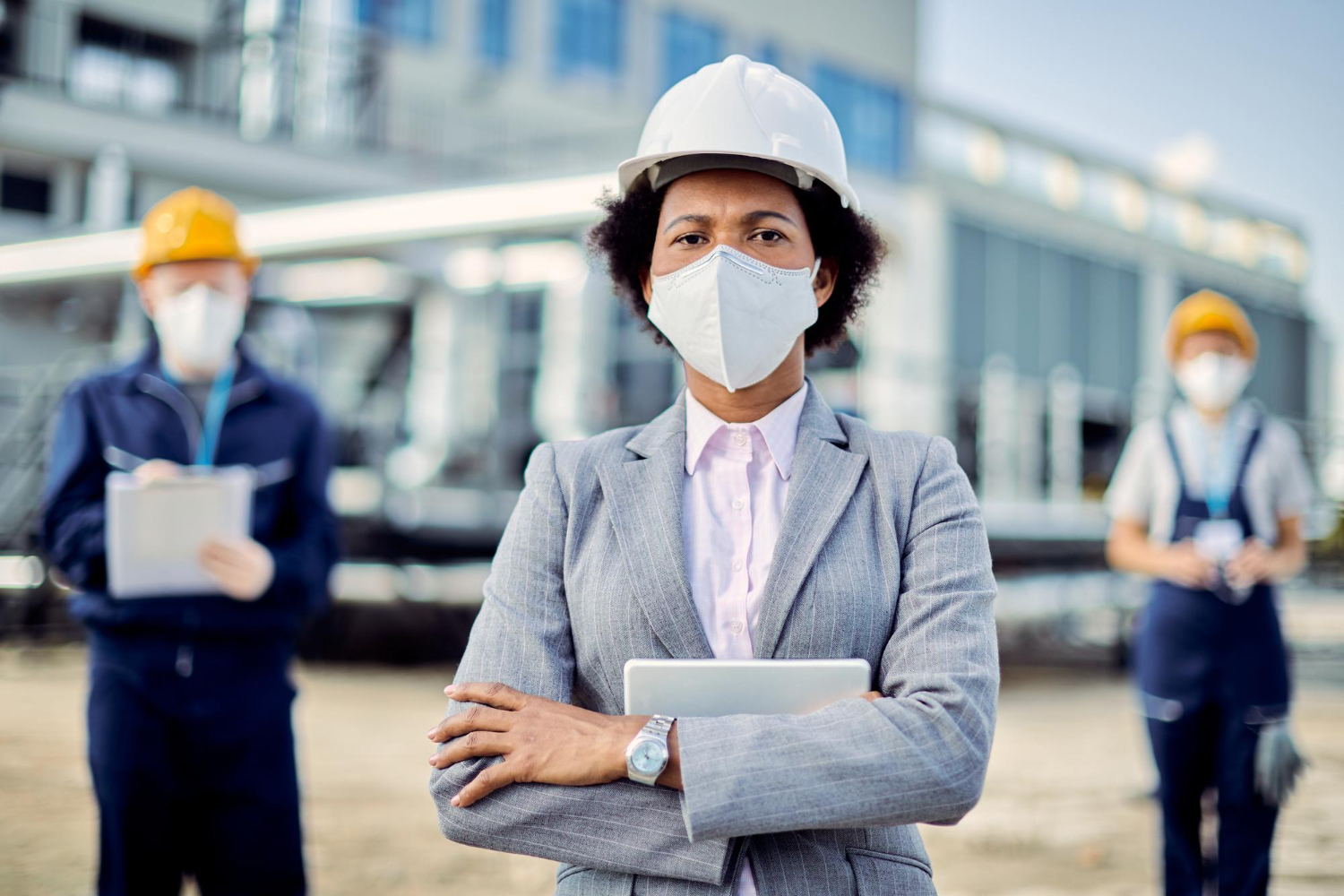 Professional in hard hat and mask at construction site